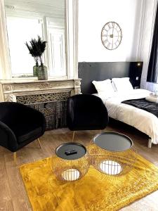 een slaapkamer met een bed en een tafel en stoelen bij NG SuiteHome - Lille I Roubaix Centre I Collège - Balnéo - Netflix - Wifi in Roubaix