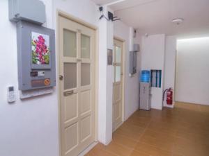 a hallway with a door with a tv on a wall at Super OYO 897 iBC36 Business Stay in Kuching