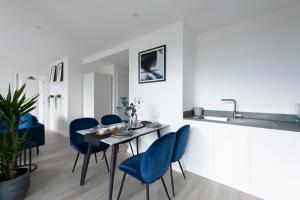 a dining room with blue chairs and a table at Luxury penthouse with stunning views near Canary Wharf in London
