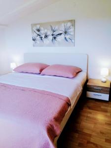 1 dormitorio con cama blanca y almohadas rosas en Guesthouse Resan, en Medulin