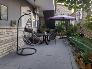 - une terrasse avec un hamac, une table et un parasol dans l'établissement Kakovatos Family Homes, à Zakharo