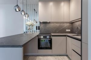 a kitchen with white cabinets and a black counter top at Apartments Taratta 1 in Trogir
