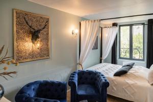 una camera con un letto e due sedie blu di 2 Appt MédiéLounge ou MédiéOld, Parking Vue magnifique par Beds76 a Rouen