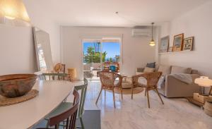 una sala de estar con una mesa y sillas en Blue Marine Gardens I with Pool, en La Herradura
