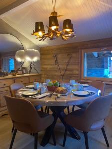 a dining room with a table with chairs and a dining room at Chalet de l'Ours : 4 étoiles-spa-proche des pistes in La Clusaz