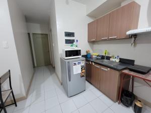 a kitchen with a refrigerator and a microwave at Camella Northpoint Nottingham building unit 231 in Davao City