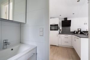 a white kitchen with white cabinets and a sink at Ostseecamp Lübecker Bucht Meeresbrise in Scharbeutz +33 photos