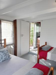 a bedroom with two beds and a sliding glass door at Storms River Tin House in Stormsrivier
