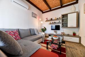 uma sala de estar com um sofá e uma televisão em Country house Oasis with private tennis court em Sveti Filip i Jakov