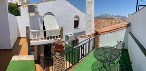 a balcony of a house with a table and chairs at Apartamento La Pedriza in Casabermeja