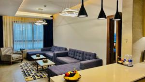 ABAR HOTEL APARTMENTS DIP-1 في دبي: غرفة معيشة مع كنبتين وطاولة