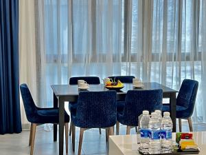 uma sala de jantar com uma mesa e cadeiras com garrafas de água em ABAR HOTEL APARTMENTS DIP-1 em Dubai