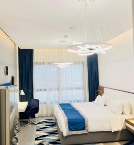 um quarto com uma cama, uma secretária e um lustre em ABAR HOTEL APARTMENTS DIP-1 em Dubai