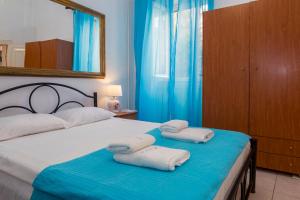 ein Schlafzimmer mit einem Bett, auf dem zwei Handtücher liegen in der Unterkunft Campiello Apartments in Korfu-Stadt + 30 Fotos