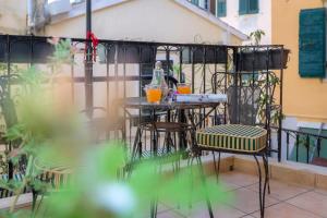 ein Tisch und Stühle auf einem Balkon in der Unterkunft Campiello Apartments in Korfu-Stadt