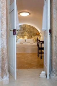 ein Schlafzimmer mit einem Bett und einem Tisch in einem Zimmer in der Unterkunft Campiello Apartments in Korfu-Stadt