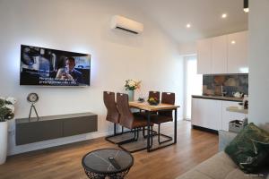 uma sala de estar com uma mesa e uma televisão na parede em Blue sky apartment em Rovinj