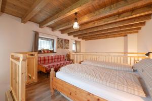 2 letti in una camera con soffitti in legno di I girasoli a Sanzeno
