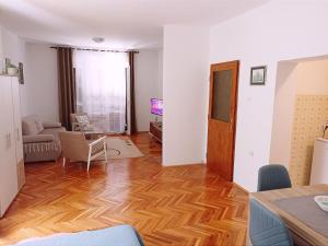 een woonkamer met een hardhouten vloer bij Apartman CITRUS Trebinje in Trebinje