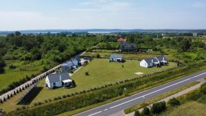 une vue aérienne sur une ferme avec des maisons et une route dans l'établissement "Lawendowe Wzgórze", à Zastań