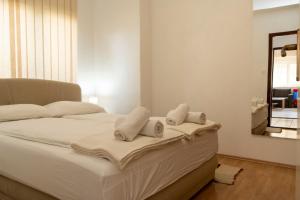 um quarto com uma cama com toalhas e um espelho em Apartman Čurčić em Knin