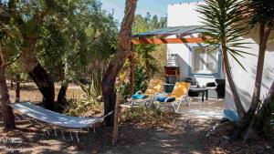 eine Terrasse mit Stühlen, einem Tisch und einem Zelt in der Unterkunft Monte Horizonte - The Private Villas - Turismo Rural - Eco & Nature in Santiago do Cacém