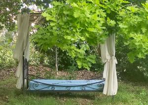 una cama colgante en un jardín con árboles en Tressan:La Calade, maison d'artiste, en Tressan