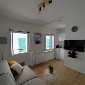 een woonkamer met een bank en een keuken bij Joli studio dans le coeur de Menton in Menton