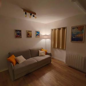 a living room with a couch and a lamp at Joli studio dans le coeur de Menton in Menton