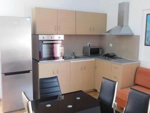 a kitchen with a table and chairs and a refrigerator at Villa Sofia in Ialyssos