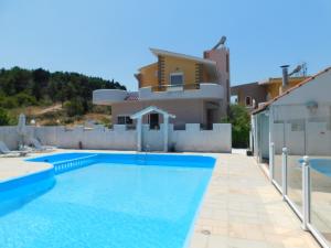 a villa with a swimming pool in front of a house at Villa Sofia in Ialyssos