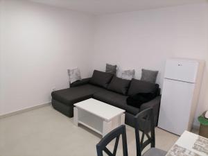 a living room with a black couch and a refrigerator at Appartment Boki in Gajac