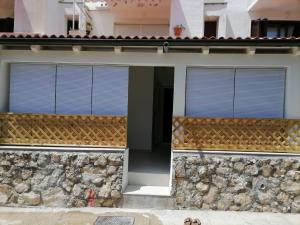 a house with two windows and a stone wall at Appartment Boki in Gajac
