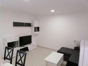 a white living room with a couch and a tv at Appartment Boki in Gajac