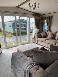 a living room with couches and a large window at Heywoods caravan holiday home in Morecambe
