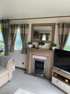 - un salon avec une cheminée et un miroir dans l'établissement Heywoods caravan holiday home, à Morecambe