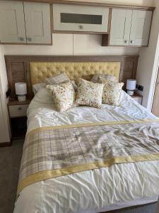 a bedroom with a large bed with pillows on it at Heywoods caravan holiday home in Morecambe