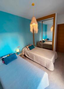 マラガにあるApartamentos Chuita Playaのベッドルーム1室(ベッド2台、鏡付)
