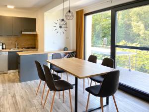 eine Küche und ein Esszimmer mit einem Holztisch und Stühlen in der Unterkunft Holiday Home Beretinec Hills in Beretinec