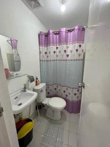 a bathroom with a toilet and a sink at Manzil Jina Laiya House Rental in San Juan