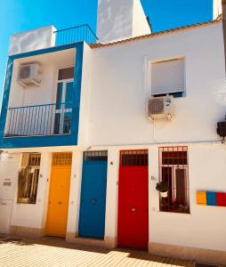 a building with different colored doors on it at Apartamentos Chuita Playa in Málaga