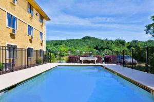 a swimming pool in front of a building at Super 8 by Wyndham Chattanooga Lookout Mountain TN in Chattanooga