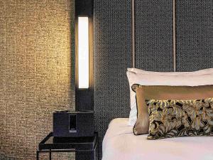 a bedroom with a bed with a pillow and a lamp at Mövenpick Hotel Wellington in Wellington
