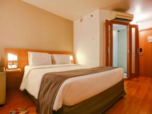 a bedroom with a bed and a dresser at Novotel RJ Santos Dumont in Rio de Janeiro