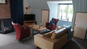 a living room with a couch and chairs and a fireplace at Vakantie appartement de Havezate in Roden