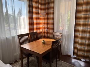 a wooden table and chairs in a room with a window at Topoliu 16 guesthouse in Šventoji
