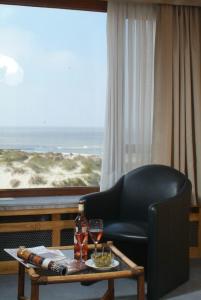 a living room with a chair and a table and a window at Sint-Laureins in Westende