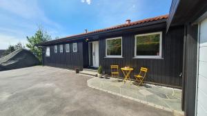 a black house with two chairs and a table at Villa with great view in Sandnes