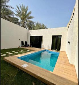 einen Pool im Hinterhof eines Hauses in der Unterkunft شاليه سدرة فاطمه in Banī Ma‘n