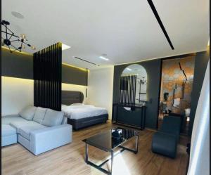 1 dormitorio con cama, sofá y mesa en شاليه سدرة فاطمه en Banī Ma‘n